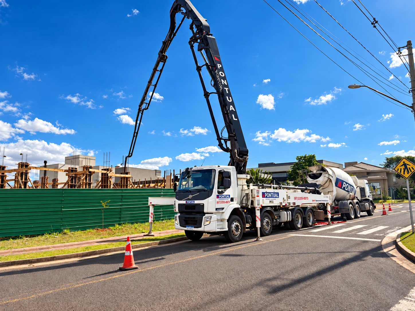 Caminhão bomba e betoneira da Pontual Engenharia em uma obra urbana